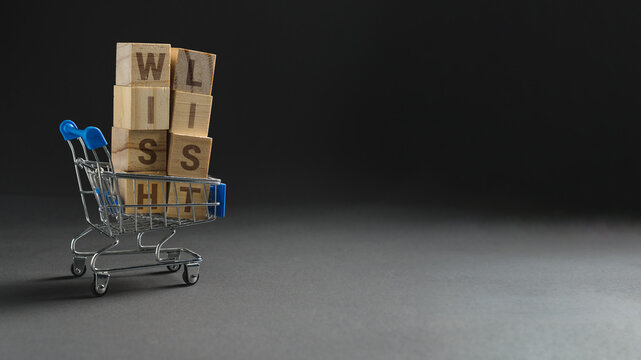Wishlist concept with shopping cart and wooden blocks on dark background