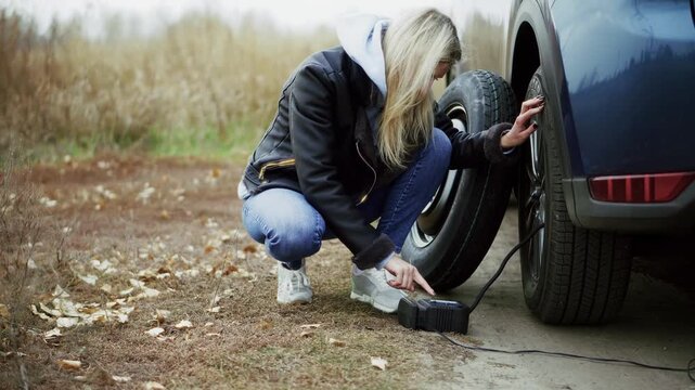 Inflating Car Tire Using Portable Air Compressor. Troubleshooting Flat Tyre Problem During Trip. Emergency Assistance 