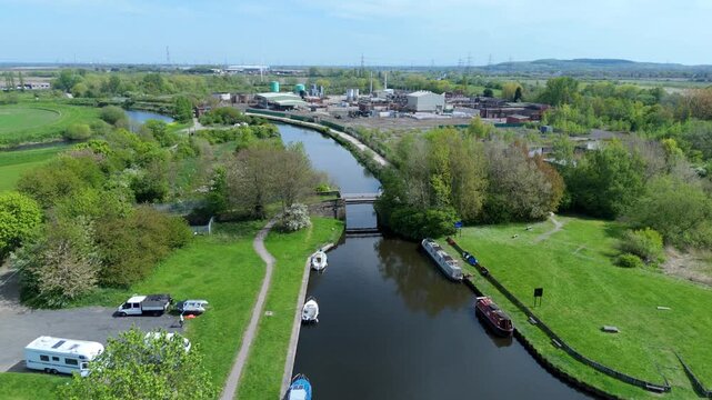 Aerial view of the Aire and Calder Navigation canal with moored narrowboats and industrial buildings Knottingley, England, United Kingdom.
