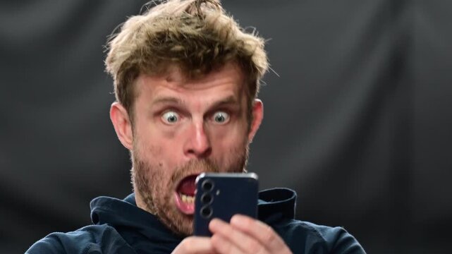 Social media culture, man looking at his phone with array of emotions, close up on the face isolated portrait shot, real time video authentic, white people. Posing for social media, modern influence c