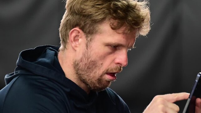 Social media culture, man looking at his phone with array of emotions, close up on the face isolated portrait shot, real time video authentic, white people. Numb zombie like behavior while looking at 