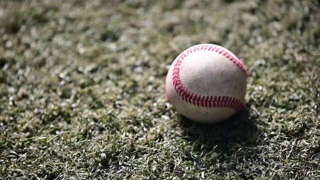used baseball close up background video, authentic light detailed isolated ball on a synthetic grass background, copy space background video