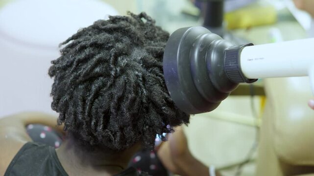 Black male teen with natural curls and twists at barber shop