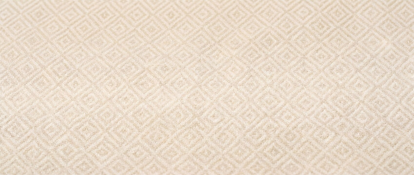 Beige fabric background with repeating diamond-shaped geometric texture pattern