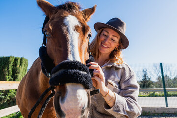 Obraz premium Woman smiling bonding with horse in rural setting
