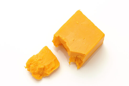Broken Chunks of Orange Cheddar Cheese on white background