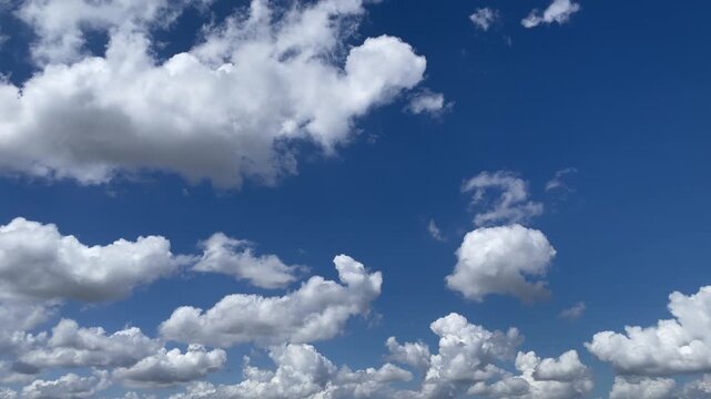 Azure Canvas of the Sky: A breathtaking panorama of a cerulean sky adorned with fluffy, cotton-like clouds, capturing a sense of boundless freedom and tranquility.