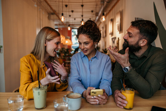 Friends socialising and talking at a coffee shop