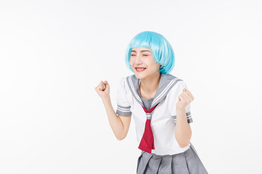 Happy cosplayer in blue wig cheering in sailor school uniform