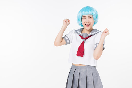 Happy cosplayer in sailor school uniform cheering with blue wig