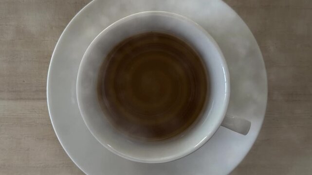 Cup of tea steams gently over wooden surface