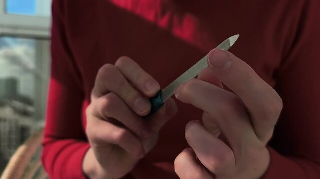 Hands holding nail file, close-up. care beauty routine by self at home.