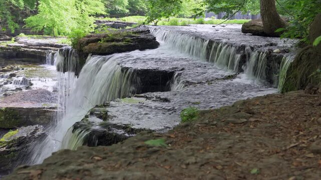 A beautiful flowing water formation under a canopy of trees called Blue Holes Falls shows the surreal, peaceful atmosphere of Old Stone Fort State Park in Tennessee.