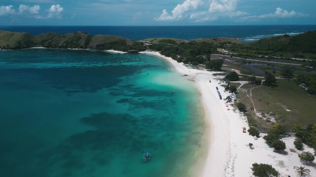 Aerial View Emerald Lagoon With Curved White Beach, Adjacent Farmland And Green Hills, Clear Shallow Patches And Reef Patterns, Calm Atmosphere Suited For Nature And Travel Visuals,Lombok