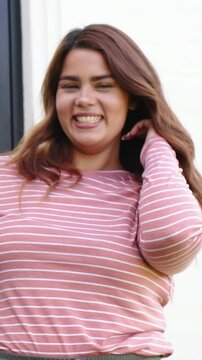 Vertical video: Smiling woman pink top fixing hair at door, friend coming hugging posing by window