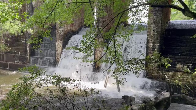 A spillway on a dam in Cumberland State Park in Tennessee shows the lake level control as water spills out the back of the dam for level control.