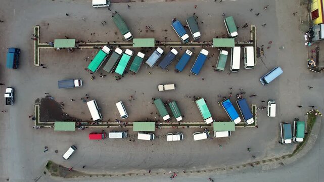 Aerial view of colorful minibuses and people at a busy transport hub with green shelters Wewak, East Sepik Province, Papua New Guinea.