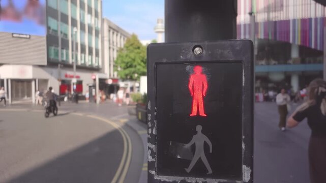 A pedestrian traffic light glowing red on a street in Liverpool. Urban crossing city scene.