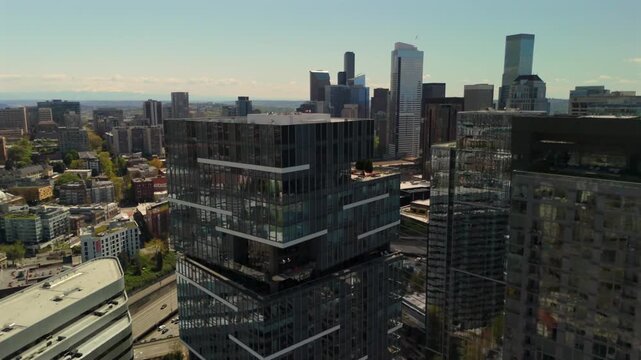 Drone flying above Seattle rooftops and modern glass buildings with waterfront skyline