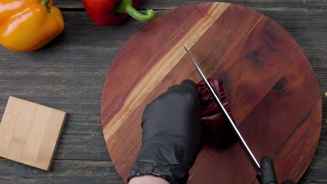 Top view of knife slicing beef ham on a wooden board with ingredients. Preparation of meat for filo pastry pie. Culinary kitchen cooking process.