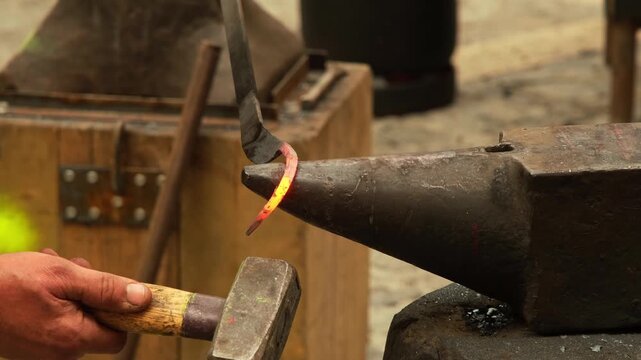 Blacksmith forging iron with a hammer and anvil