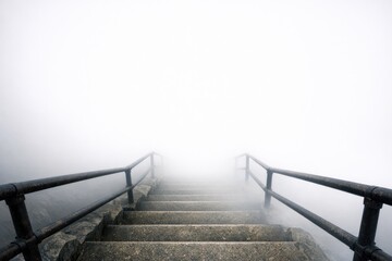 Obraz premium A set of stairs ascending into thick fog, great for mystery or suspense scenes