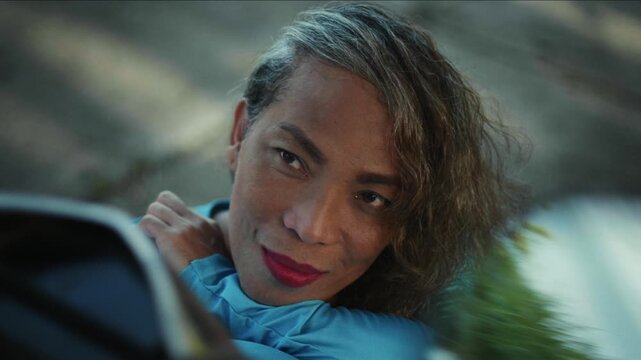 Portrait of a beautiful transgender woman with red lipstick smiling and looking confidently at camera