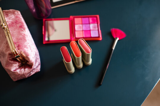 Set of cosmetic products with blush in sticks on table close up. Make up collection.