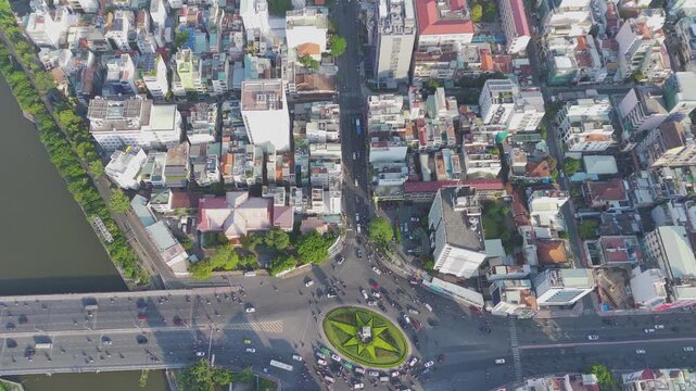 Drone tilt-up from top-down to high angle view of busy traffic towards District 1, Saigon