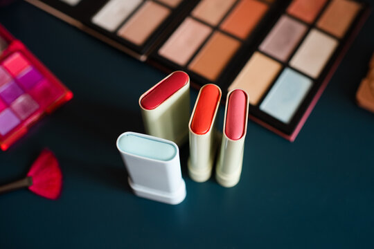 Set of cosmetic products with blush in sticks on table close up. Make up collection.