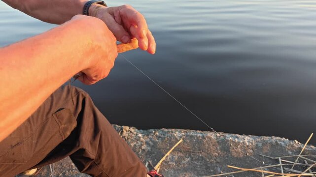 Fisherman removes fish from hook. Close up of  fisherman's hands. Summer fishing. First catch.