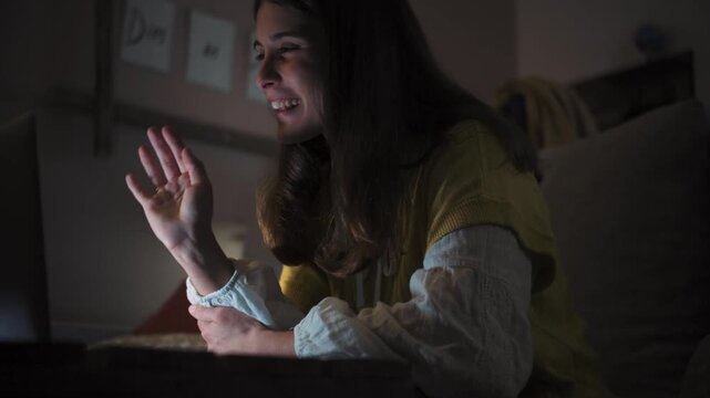 Young woman at home at night using her laptop. Remote work and digital lifestyle concept in a cozy indoor setting.