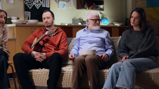 Fun grandpa sits next to his grandchildren and do not understand what going on