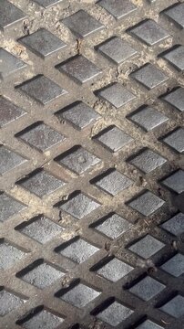 Close up of vertical metal diamond plate texture on manhole cover