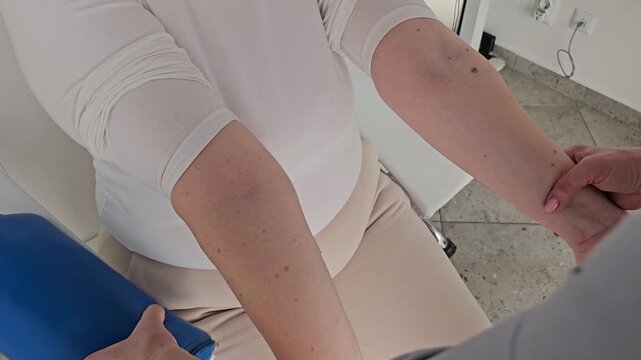 Laboratory technician carefully takes a blood sample from a pregnant woman's arm during a routine prenatal checkup in a modern medical clinic.
