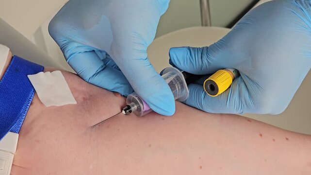 Laboratory technician carefully takes a blood sample from a pregnant woman's arm during a routine prenatal checkup in a modern medical clinic.