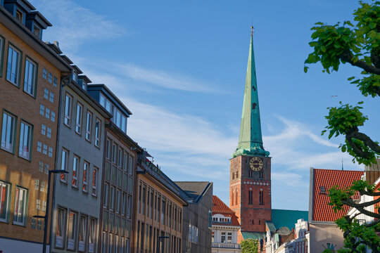 Historic European Luebeck cityscape with clock tower and traditional buildings under blue sky
