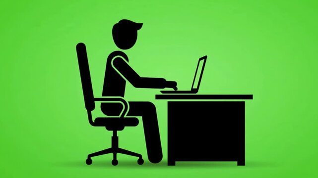 Silhouette of a person sitting at a desk working on a laptop computer against a bright green background at work.