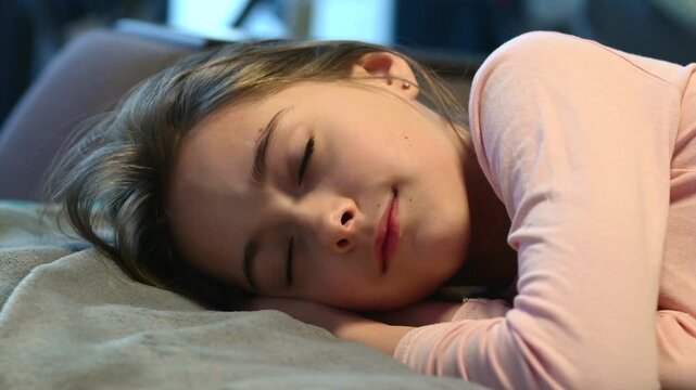 Girl sleeping on a soft bed at home. Child resting with closed eyes, calm facial expression and natural pose in a cozy indoor lifestyle scene. Tender family moment, healthy sleep, comfort, relaxation 