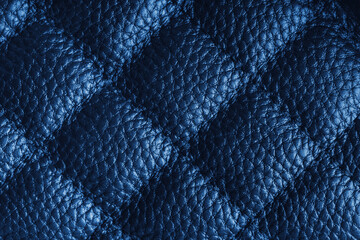 Fototapeta premium Close up, macro of blue quilted leather texture with stitched diamond pattern, luxury material surface shining metal effect for fashion, upholstery or design wallpaper, rough, relief background