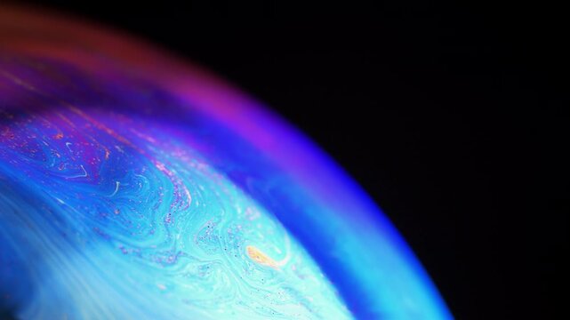 Rainbow multilayer film. Spherical abstraction of iridescent blue, yellow and red colors with soft focus. The natural environment.
