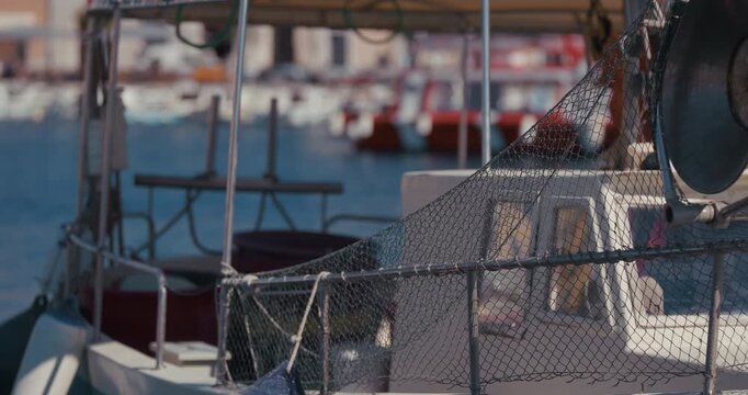 Close up of a fishing net attached to the railing of a boat in a marina in Rovinj, Croatia.