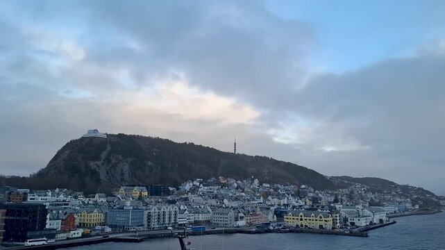 Alesund Norway jan 14 2025 Stormy Harbor View Of Coastal Town With Hillside Buildings And Docked Ships Under Gray Clouds