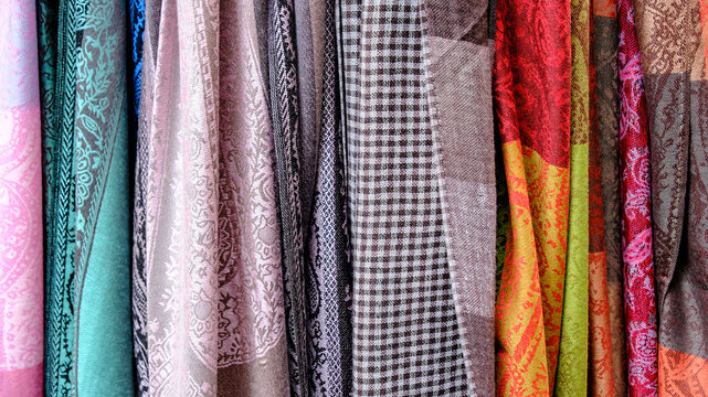 Colorful scarves hanging displaying textile patterns and textures