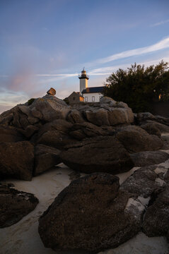Copy space vertical travel banner with Pontusval lighthouse on rocky coast at sunrise, Brittany , France. Tourist landmark