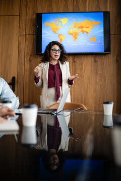 Businesswoman presenting global strategy discussing world map