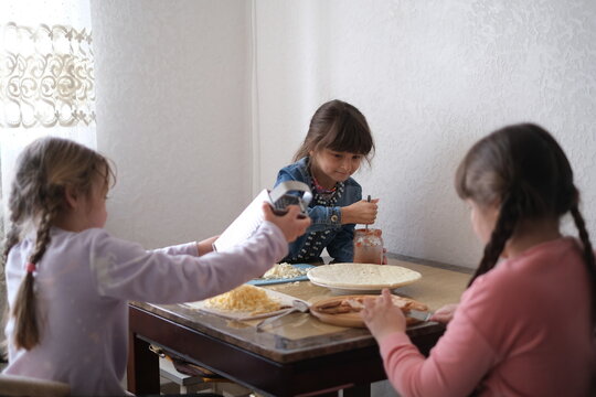 Kids make food together in a kitchen on a weekday afternoon with smiles and laughter