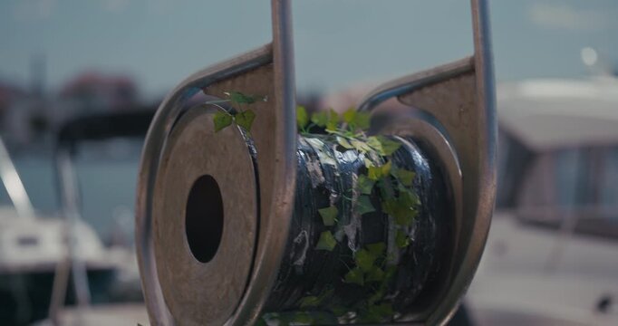 Close view of a cable reel with ivy decoration at a marina in Rovinj, Croatia.