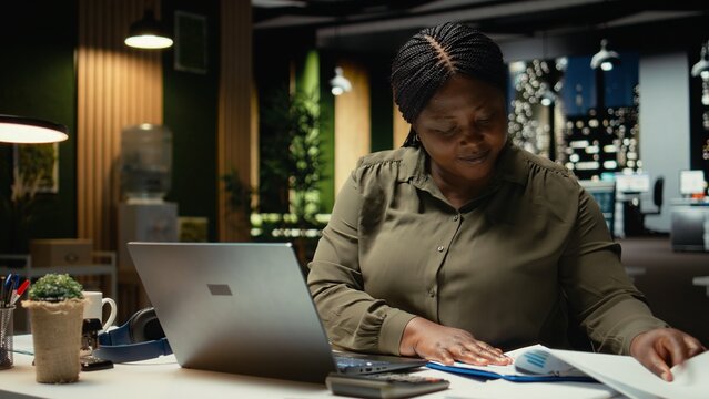 Engaged general manager researching market data and designing strategies to meet business goals, using spreadsheets for proofreading. Woman does after hours work for the enterprise. Camera A.