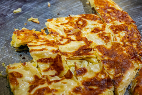Eating plaza inside the restaurant  Fresh cheese pie lies on the table. Omelet of potatoes cooking in a pan. Omelet of potatoes cooking in a pan. Turkish style meat stuffed filo dough borek served kol